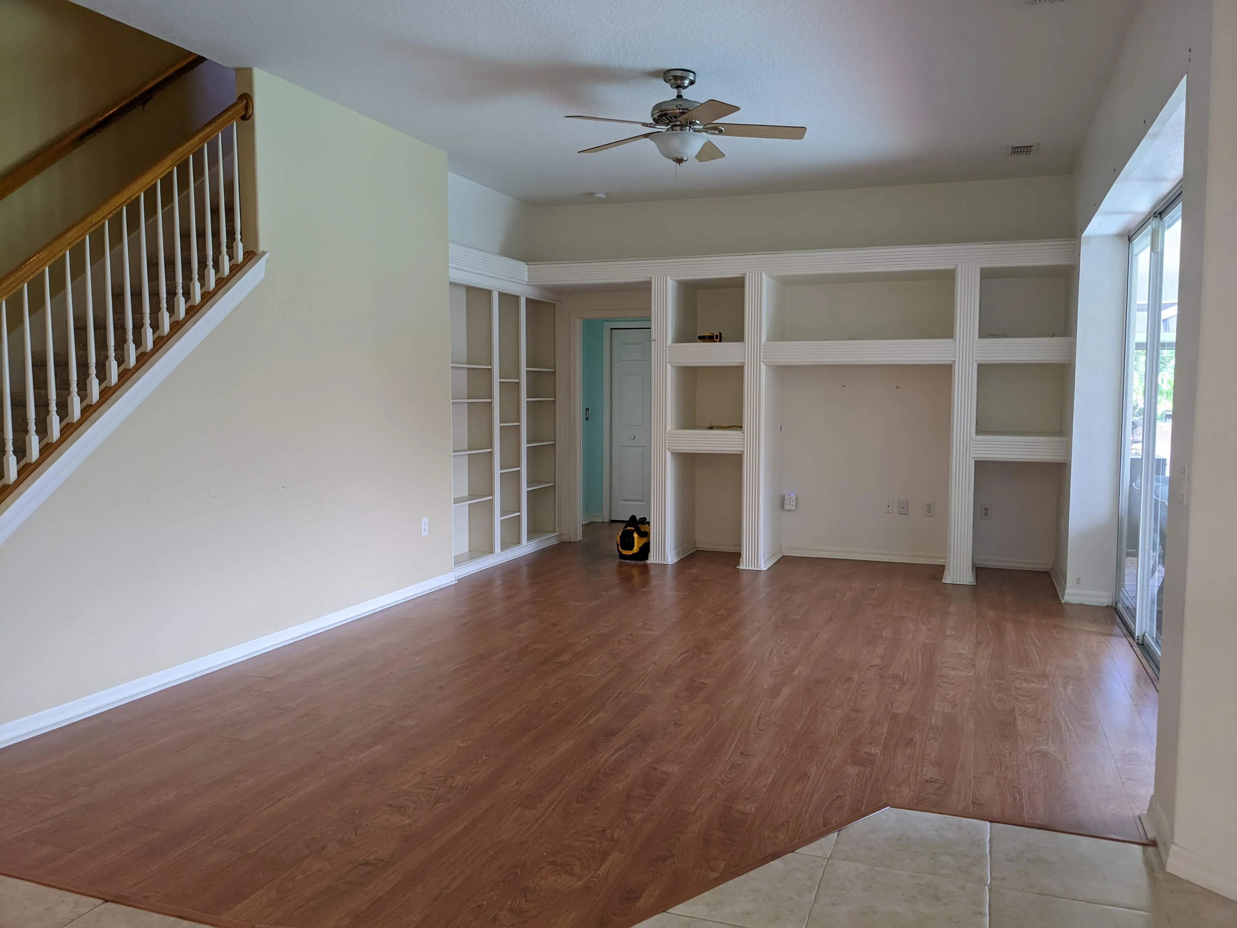 Before: Custom white oak living-room built-ins beside a porcelain fireplace surround with a wood mantel, and board & batten and shiplap accent wall